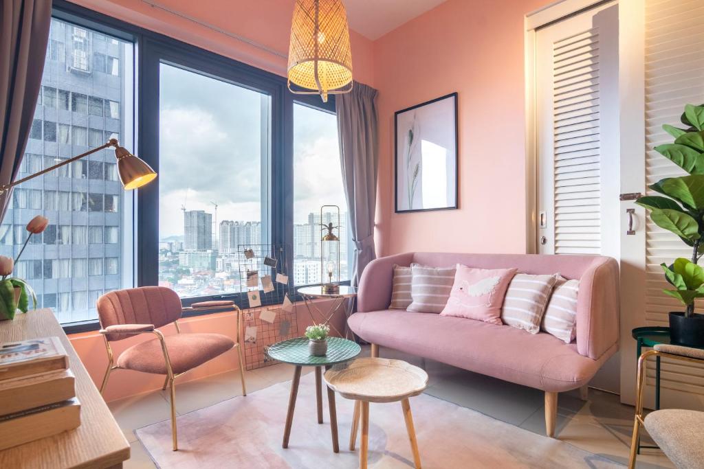 乔治市Georgetown Tropicana 218 by Airlevate Suites的客厅设有粉红色的沙发和大窗户
