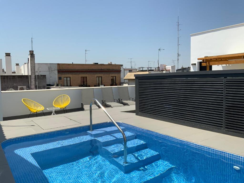塞维利亚Apartamentos Rivero 8的建筑物屋顶上的游泳池
