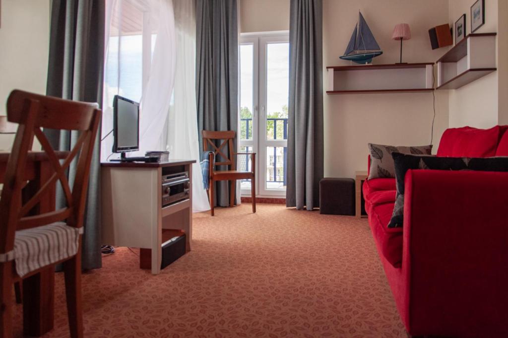 查普伊Villa Baltic 14 Chałupy的客厅配有红色沙发和电视