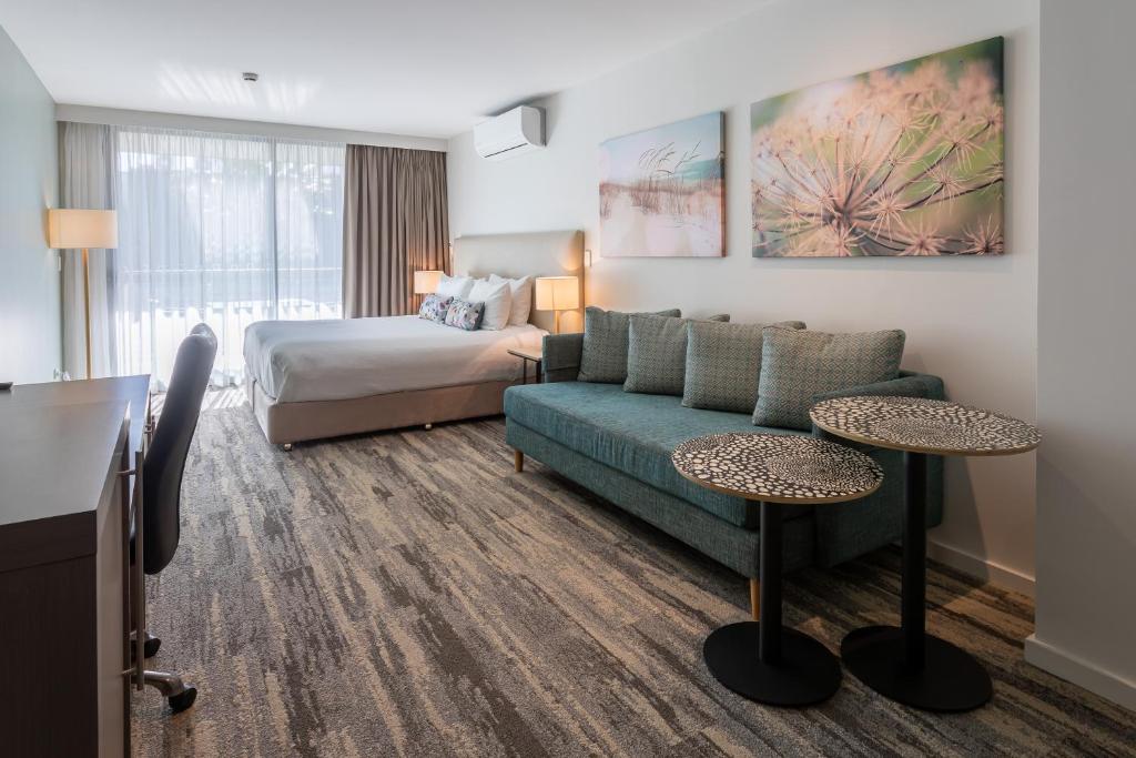 纳拉宾Narrabeen Sands Hotel by Nightcap Plus的酒店客房设有一张沙发和一张床