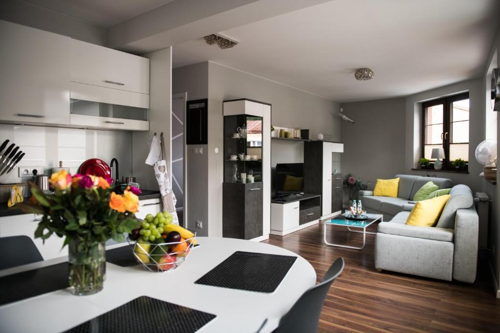 亨齐内Apartamenty Królewskie的厨房以及带桌子和沙发的客厅。