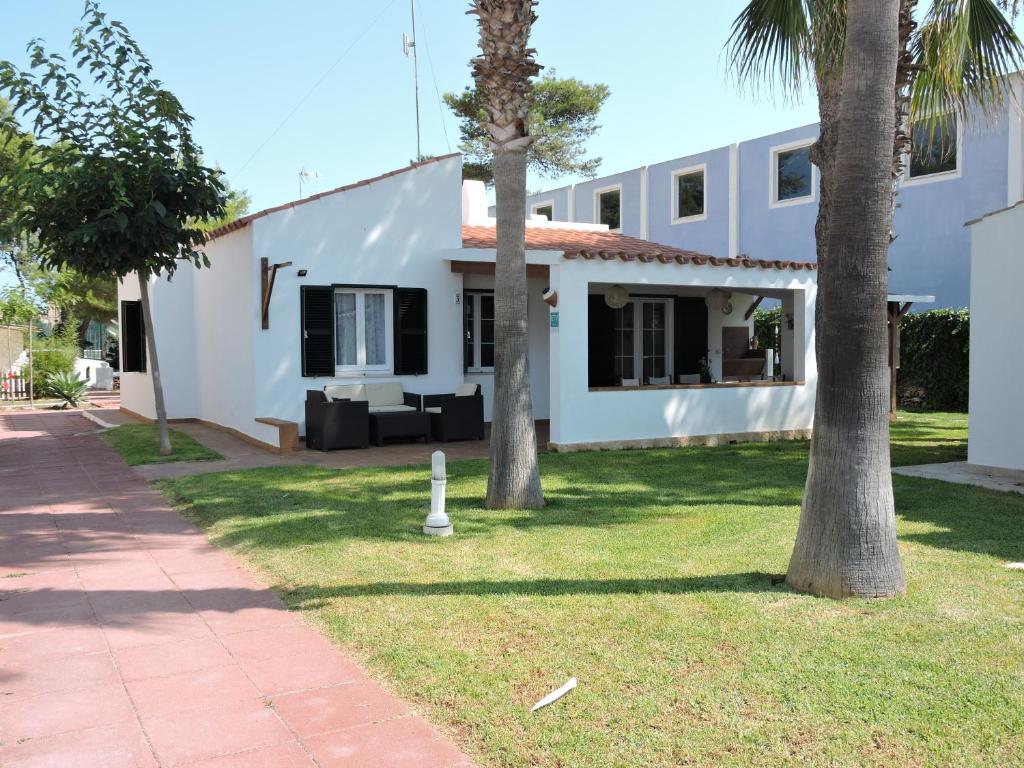 卡兰博希Chalet Cerca de la Playa的院子里两棵棕榈树的白色房子