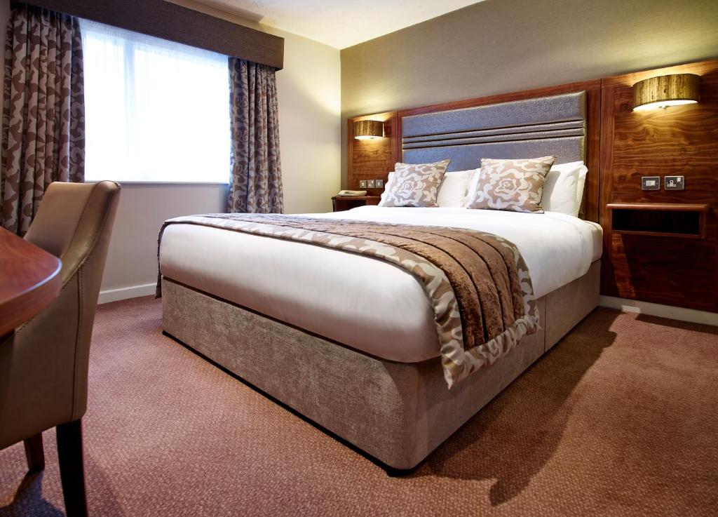 哈德斯菲尔德石楠府酒店的一间设有大床和窗户的酒店客房