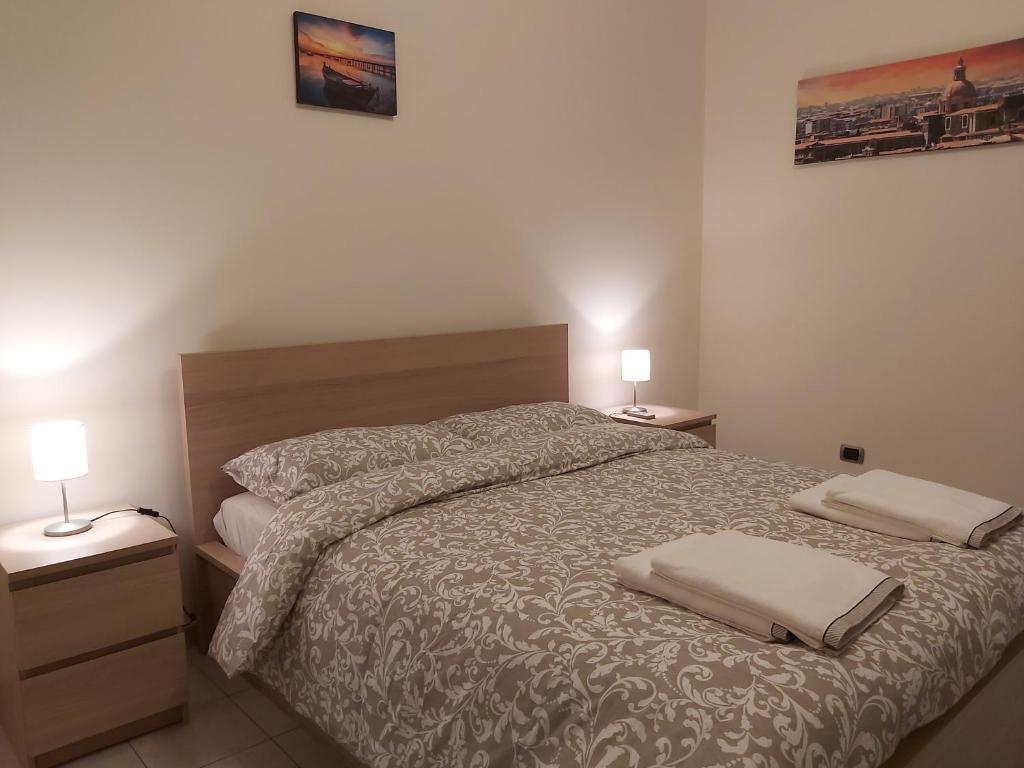 卡塔尼亚COCO Apartments的一间卧室配有一张带2个床头柜和2盏灯的床。