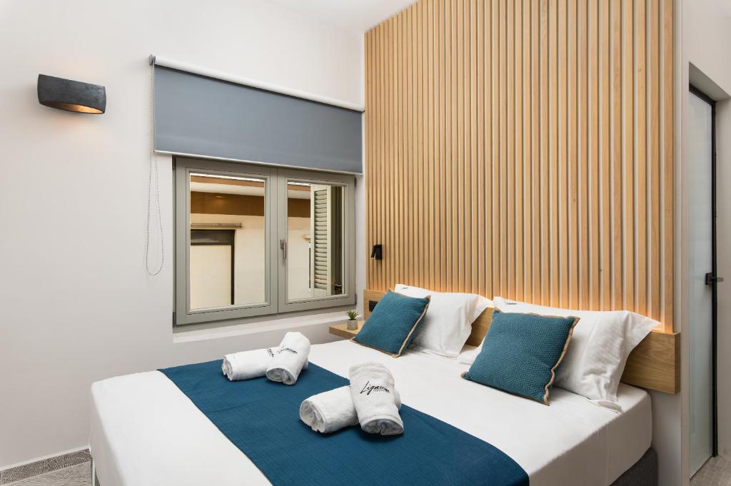 干尼亚Lignum Suites Chania的卧室里有一张白色的大床，配有蓝色的枕头