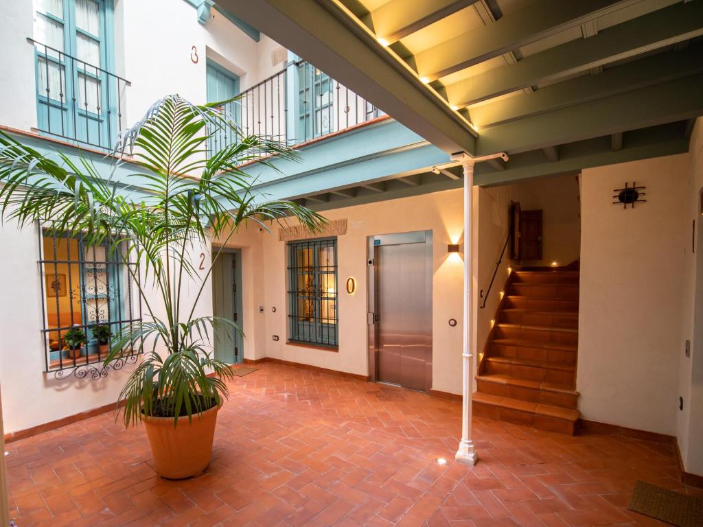 塞维利亚Casas de Sevilla - Apartamentos Vidrio 7的走廊上,有楼梯和植物的建筑