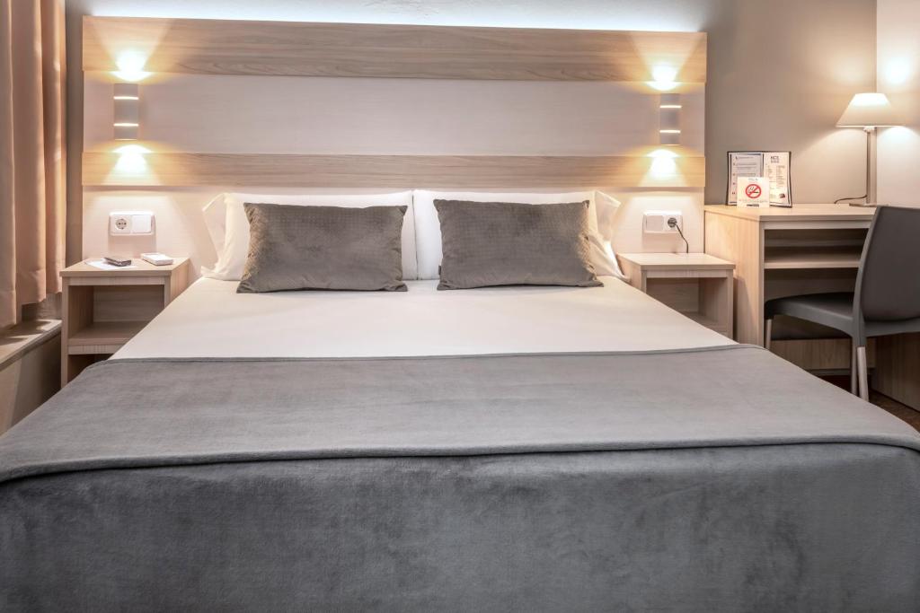 塔拉戈纳Hotel Catalunya Express的一间卧室配有一张大床和一张书桌