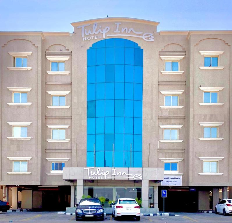 达曼Tulip Inn Corniche Dammam的门前有车辆停放的酒店