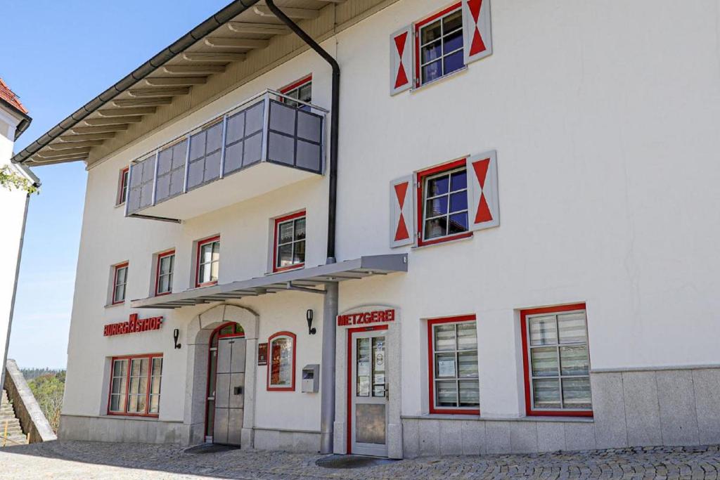 KollnburgBurggasthof Hauptmann的白色的建筑,有红色的窗户