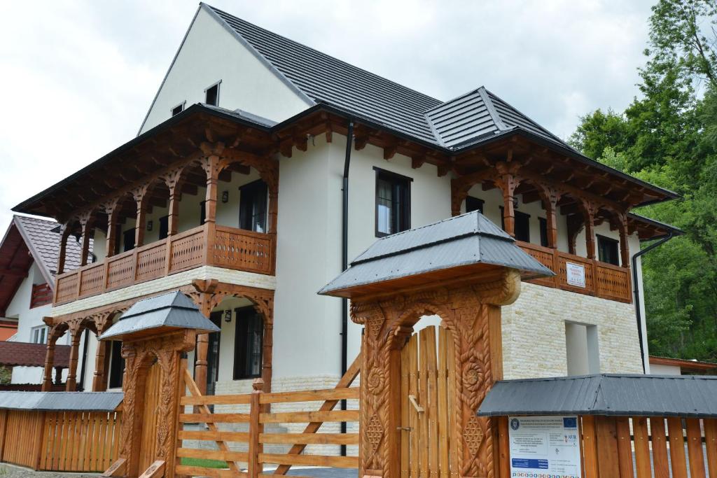 VăleniPensiunea ARMONIA的一座带木栅栏的大型白色房屋