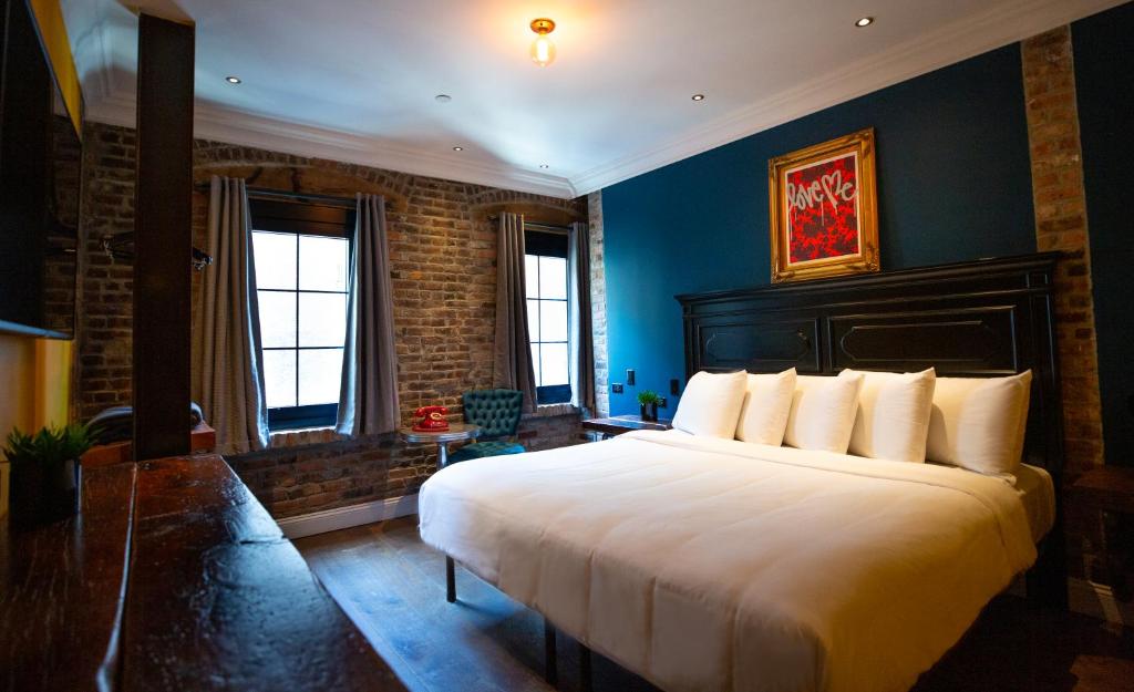 纽约苏豪酒店的卧室配有白色大床和蓝色的墙壁