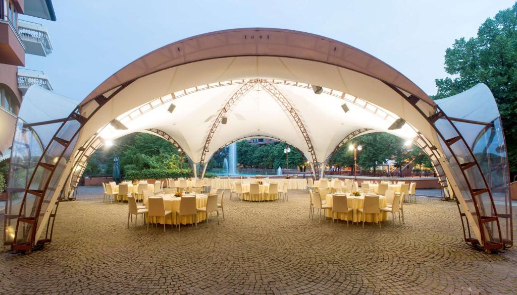 塞格拉泰NH米兰2酒店的一个带桌椅的大型白色帐篷