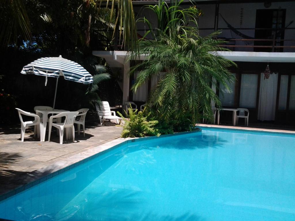 嘎林海斯港Exclusive Guest House的蓝色游泳池配有椅子和遮阳伞
