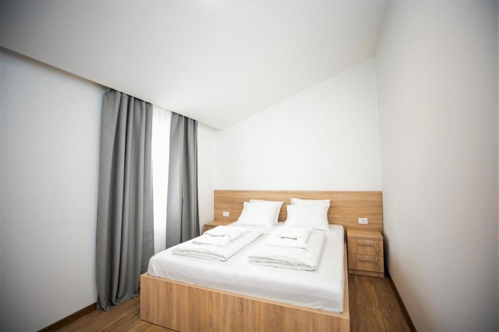 默主歌耶APARTMANI M&J Međugorje的一间卧室配有带白色床单和枕头的床。