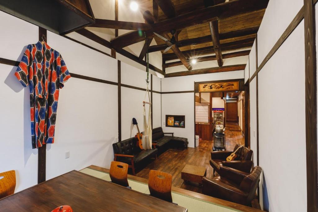 松本Couch Potato Hostel - Vacation STAY 88233的客厅配有木桌和椅子