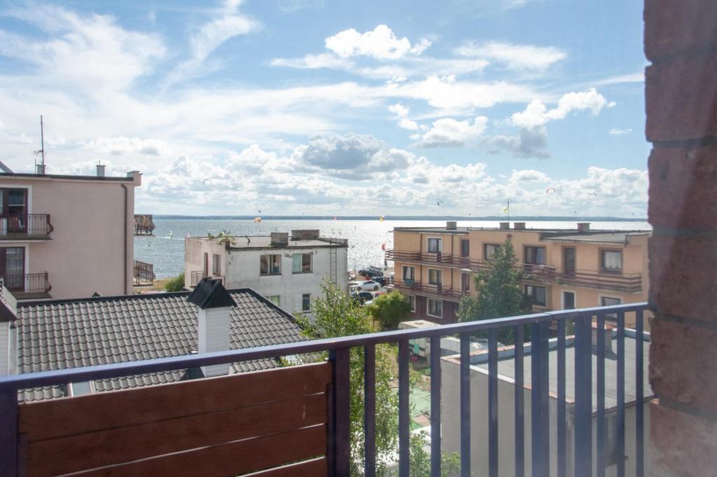 查普伊Villa Baltic Chałupy - Apartament nr 14A的阳台享有大海和建筑的景致。