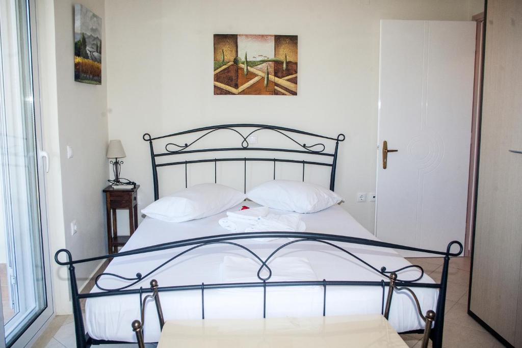 雷夫卡达镇Maria Apartments的一张带白色床单和枕头的床