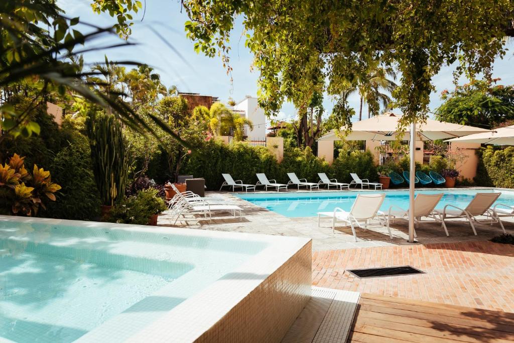 巴亚尔塔港San Trópico Boutique Hotel & Peaceful Escape的毗邻度假酒店的带躺椅的游泳池