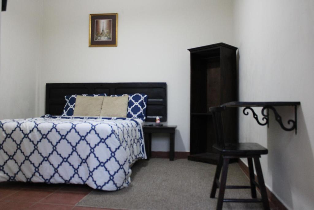 康塞普西翁德阿塔科罗斯波尔图尼斯蒂阿塔克宾馆的卧室配有1张床、1张桌子和1把椅子
