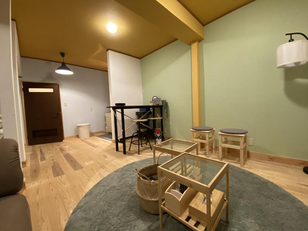会津若松mooi guesthouse 日新町的客厅配有桌子和一些椅子