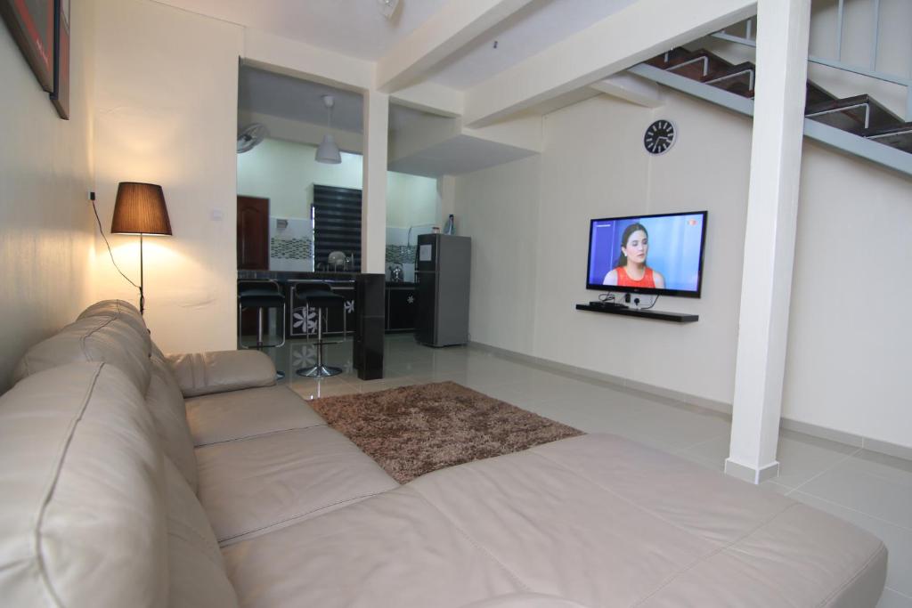 巴力拉惹Homestay Hj Esmon 3 UTHM Parit Raja的客厅配有沙发和墙上的电视