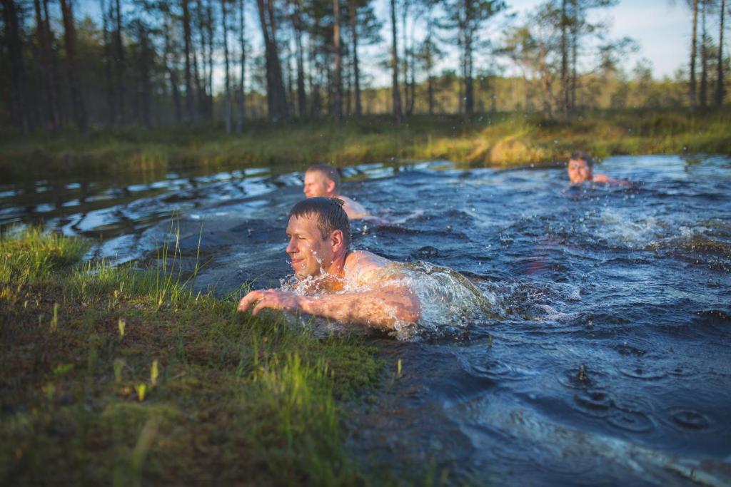 基维厄利Tuhamäe hosteli puhkemaja的三个孩子在树林里河边游泳