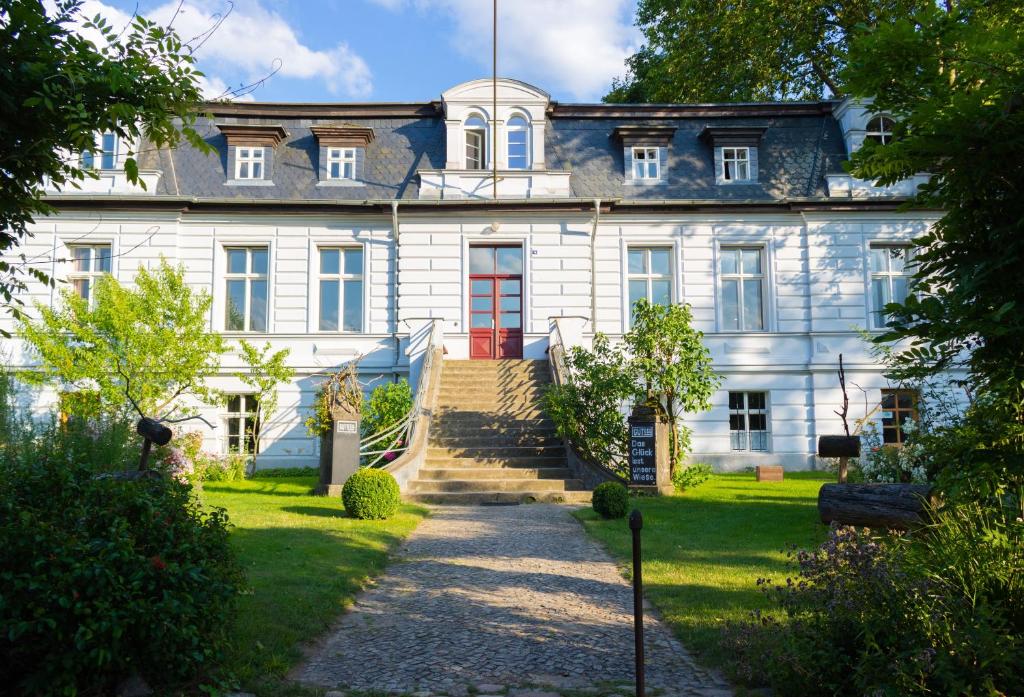 菲尔斯滕贝格Gut Boltenhof的一间设有红色门的大型白色房屋