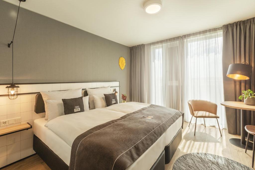 纽伦堡the niu Leo的酒店客房设有一张大床和一张桌子。