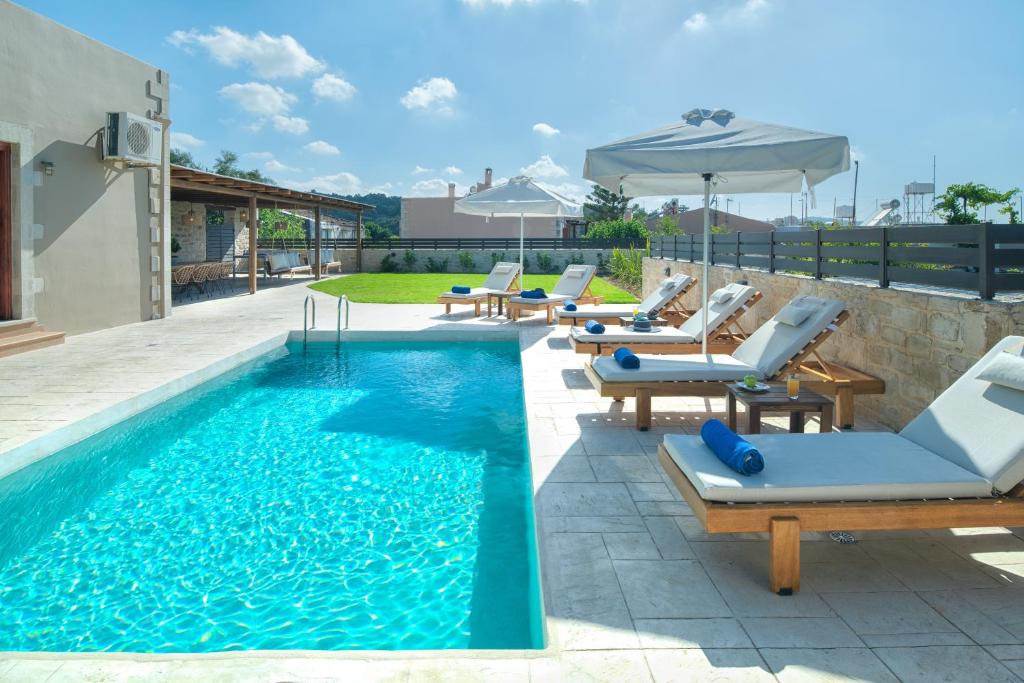 PeramaKalypso Villa, Detached Privacy, By ThinkVilla的一个带躺椅和遮阳伞的游泳池