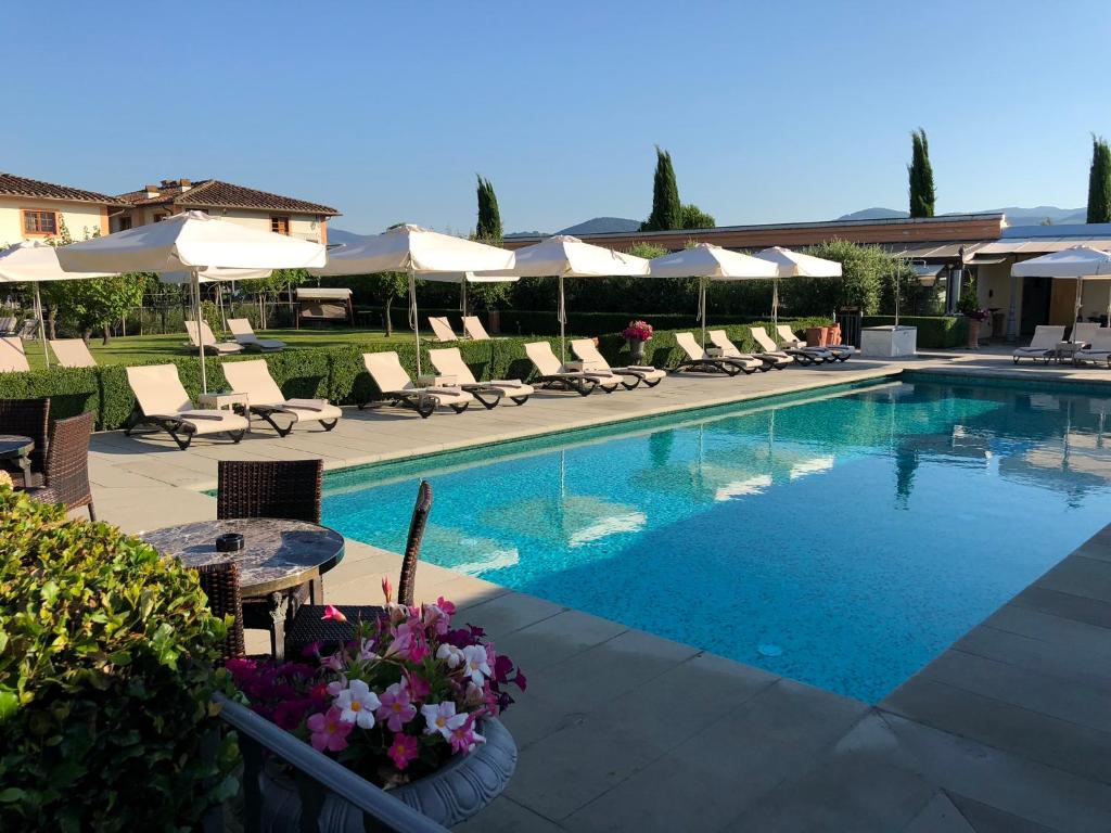 佛罗伦萨佛罗伦萨奥勒米别墅的一个带桌椅和遮阳伞的游泳池