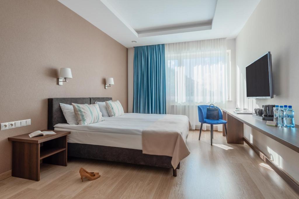 格丁尼亚Green Loft Gdynia的酒店客房配有一张床、一张书桌和一台电视。