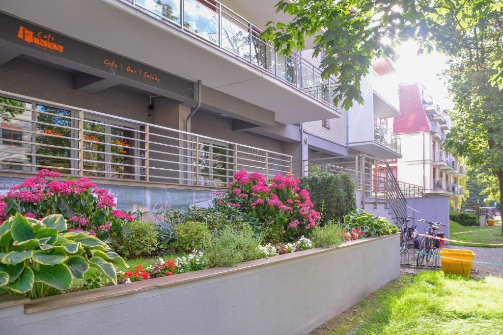 斯维诺乌伊希切Apartamenty na Wyspie - Feniks - Parking的一座有鲜花和植物的建筑