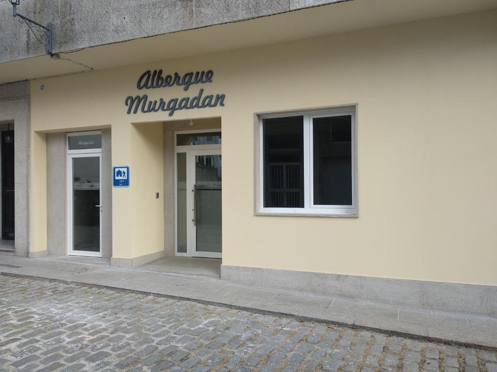 帕德隆Albergue & Rooms Murgadán的白色的建筑,旁边标有标志