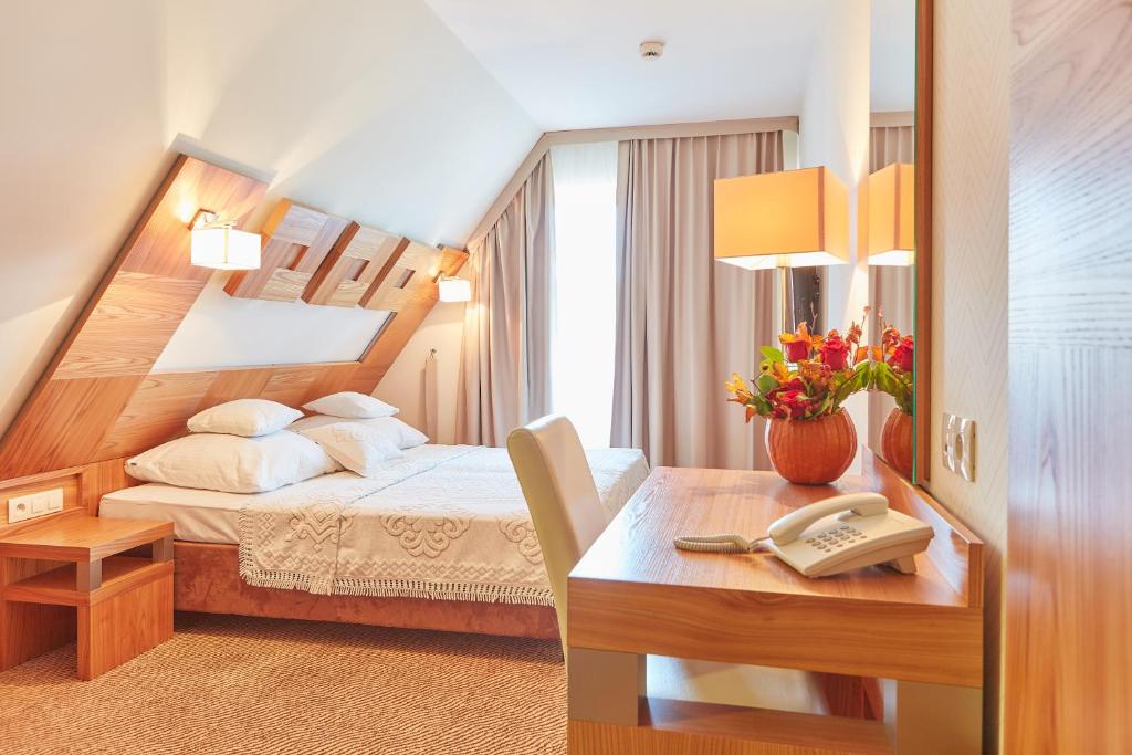 布科维纳-塔钱斯卡斯波尼克卡酒店的一间卧室配有一张床和一张带电话的书桌