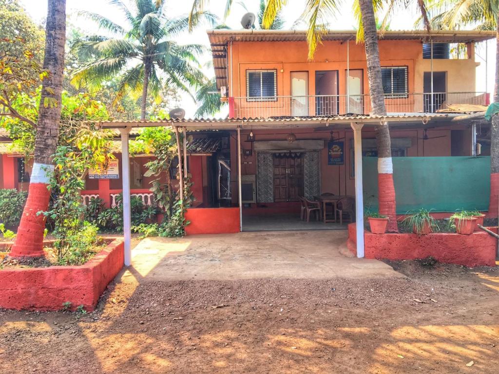 达博利Aviraj Nivas的前面有棕榈树的房子