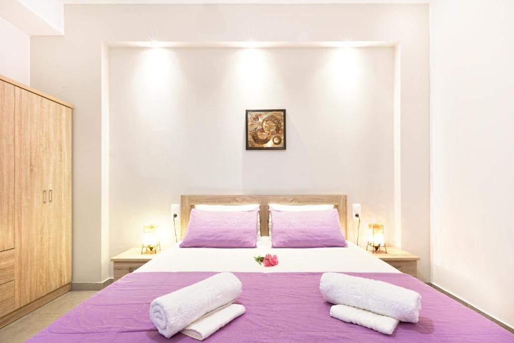 斯基亚索斯镇Stenaki的一间卧室配有一张大床,提供紫色床单和枕头