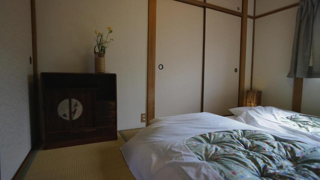 京都Demachi House的一间卧室配有一张床和电视