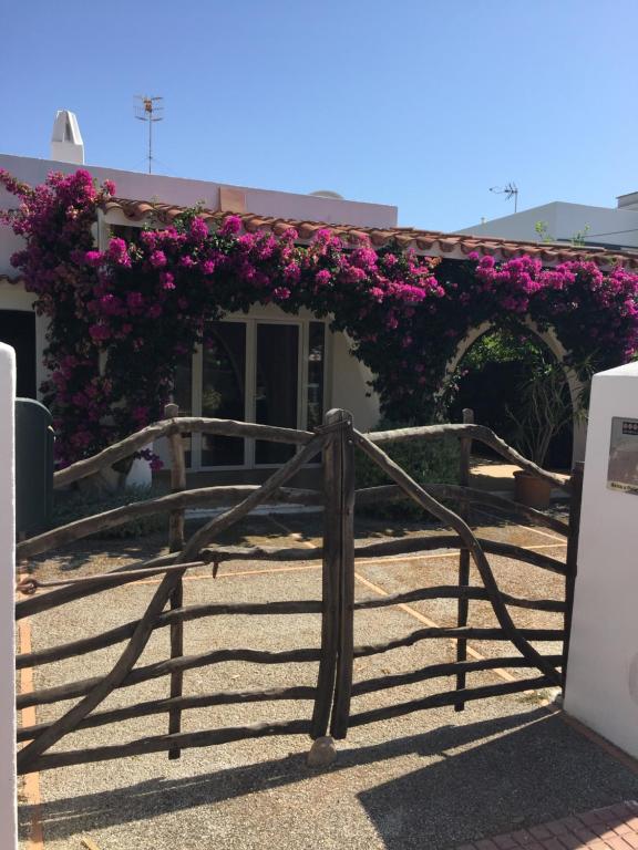 卡拉布兰卡Chalet tranquilo y acogedor a 50 metros de la playa的一座建筑上带紫色花的大门