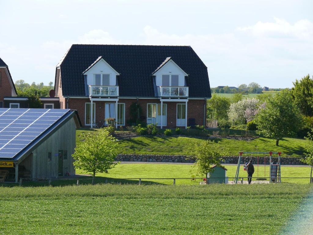 北滩岛Ferienhaus Wattenmeerblick的草坪上带太阳能电池板的房子