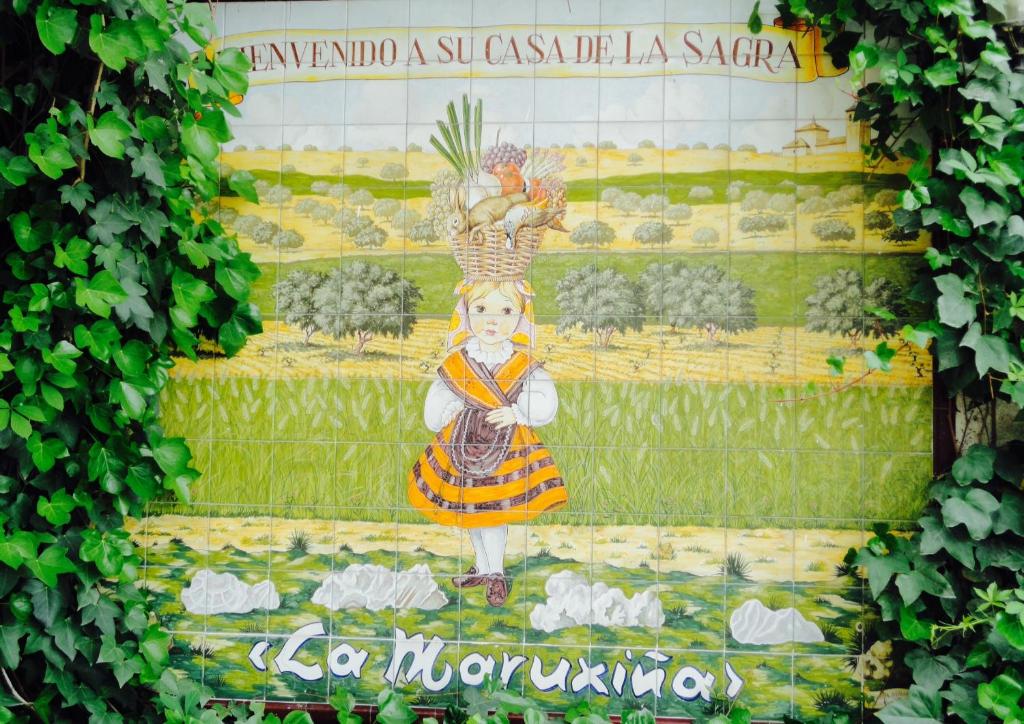La Alameda de la SagraHotel La Maruxiña的墙上挂着一个抱着鸡的女孩的照片