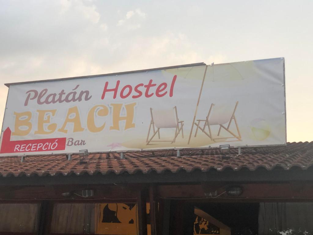 巴拉顿博格拉尔Beach Hostel Balatonboglár的屋顶上带三把椅子的海滩酒吧的标志