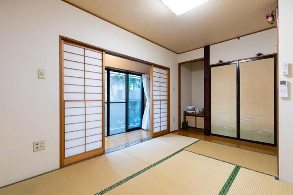 川崎Noriko's Home - Vacation STAY 8643的一间空房间,有门窗和地毯