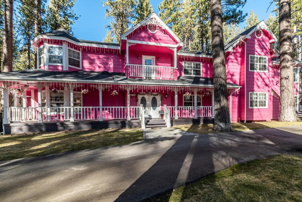 大熊湖Apples Bed and Breakfast Inn的前面有一棵树的粉红色房子