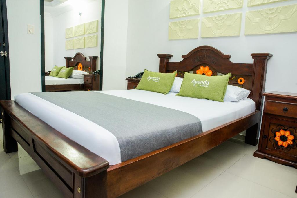 巴兰基亚Ayenda 1315 Candiac的一间卧室配有一张带绿色枕头的大床