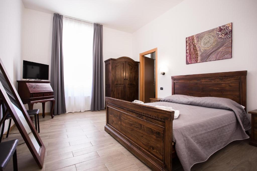 米兰Hotel Amico的一间卧室配有一张床、一台电视和一架钢琴