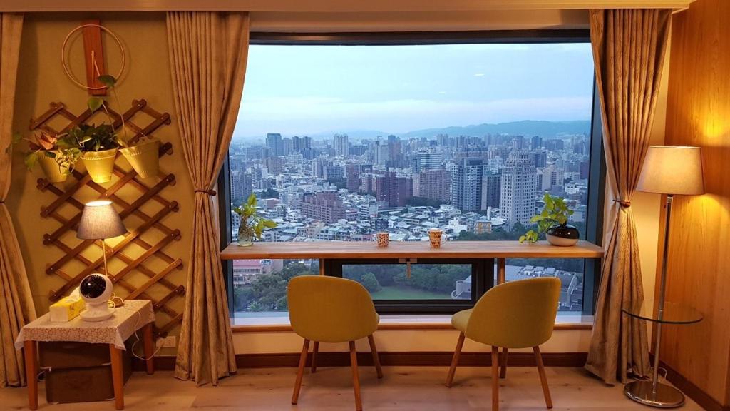 台中市雲雀高樓景觀公寓的客房设有大窗户,享有城市美景。