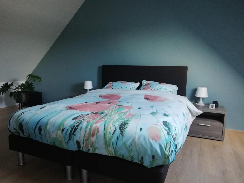 LangemarkB&B Lora的一间卧室配有一张带花卉棉被的床