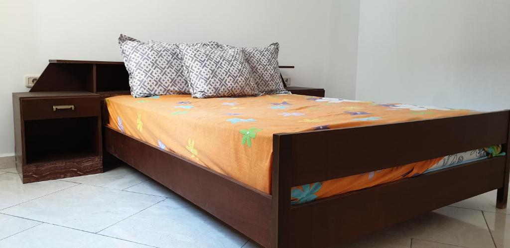 Sidi Bou JoblineMNAKAA BEACH的一张带橙色棉被和枕头的床
