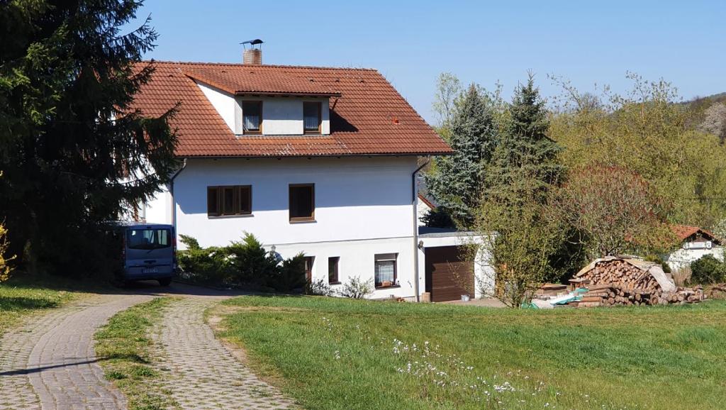 OttendorfFerienwohnung Kirnitzschtal的白色的房子,有红色的屋顶和道路