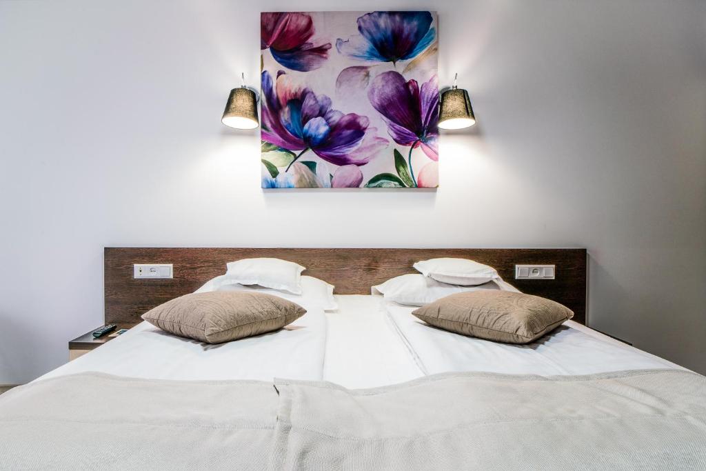 坎普朗莫道尼斯伊顿酒店的一张带两个枕头的床和墙上的绘画